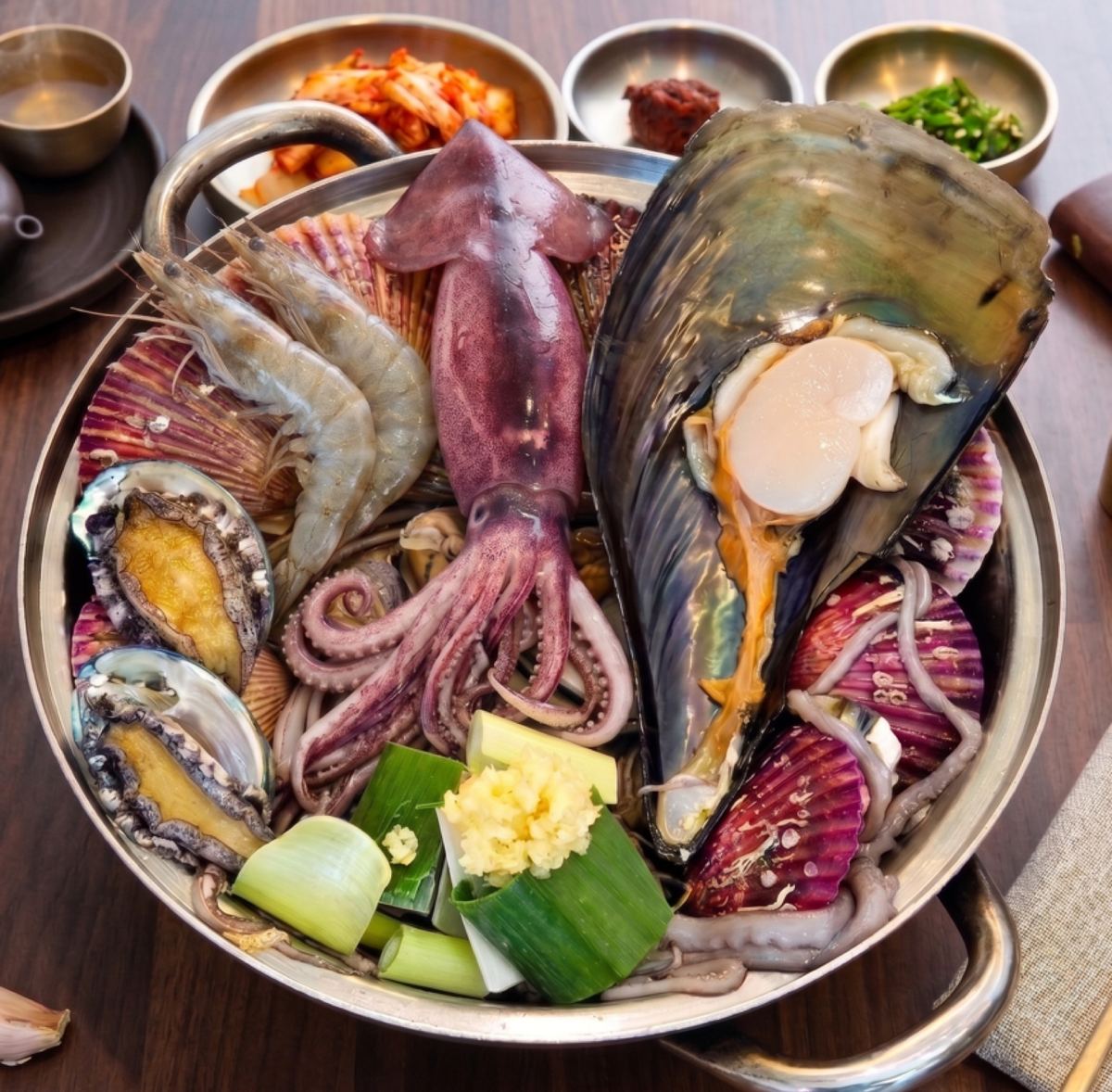 전복과 큰 오징어, 새우, 홍합이 가득 담긴 조태산해물칼국수